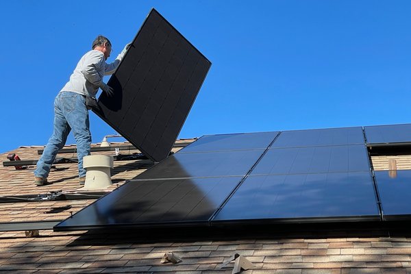 Man installiert Solaranlage auf einem Dach.