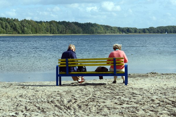 zwei ältere Damen sitzen auf einer Bank mit Aussicht auf den Templiner See