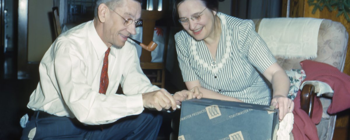 altes Foto vom älteren Ehepaar zuhause mit Geschenk