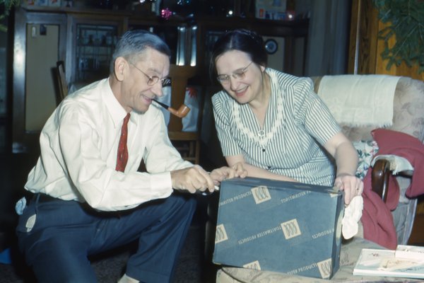 altes Foto vom älteren Ehepaar zuhause mit Geschenk